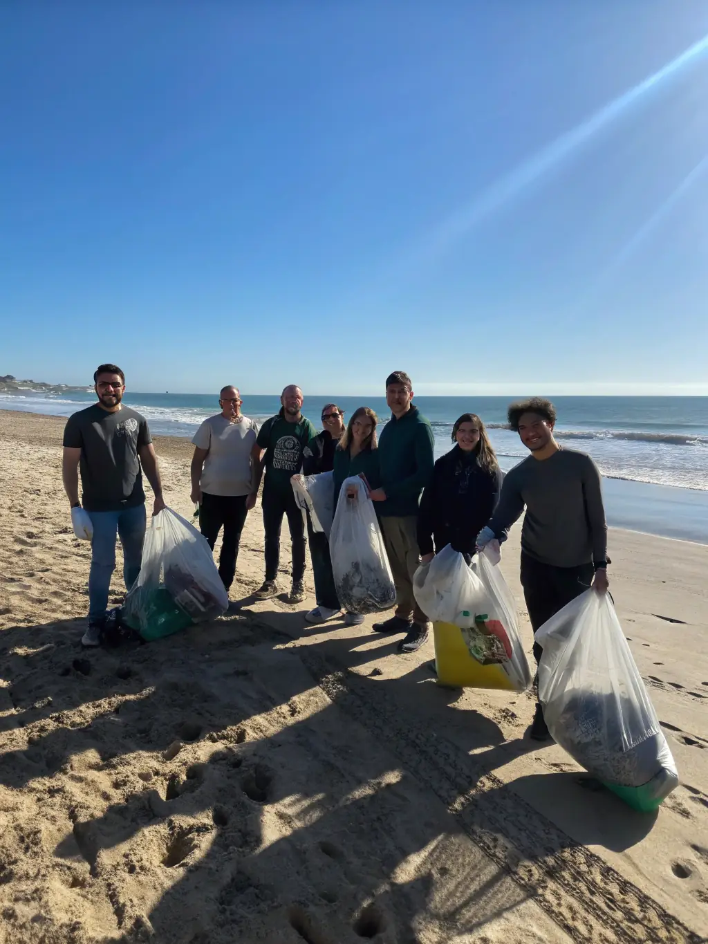 A group of people cleaning up a local beach, highlighting efforts to reduce pollution and protect marine ecosystems.